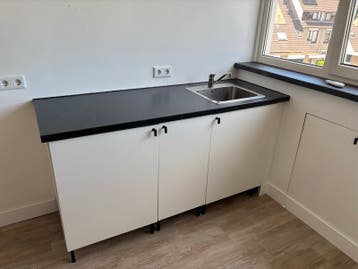 Compacte keuken met spoelbak en donker werkblad