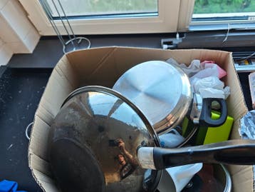 Diverse keukenspullen: pannen, kopjes, borden en bestek