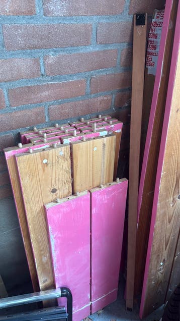 Houten planken van een roze boekenkast.