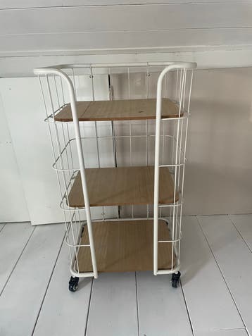 Wit metalen rek met houten planken op wieltjes