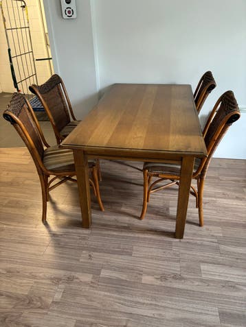 Houten eettafel met 4 rotan stoelen
