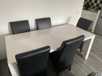 Moderne witte eettafel met 5 zwarte stoelen