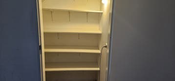 Planken trappenkast + grote kast in gang met planken