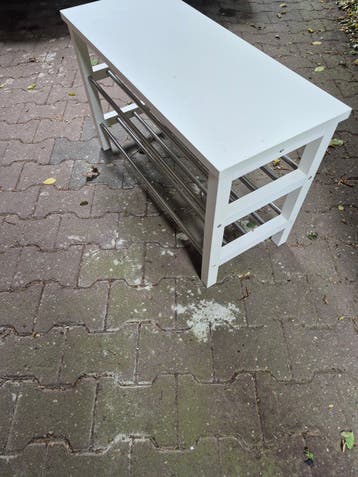 Witte schoenenbank met metalen rekken