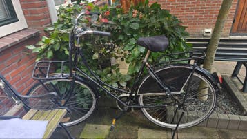 Zwarte damesfiets met defect achterwiel