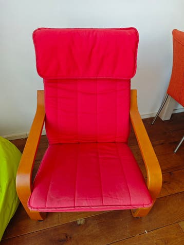 MOET NU WEG. Leunstoel Ikea, rood kussen.