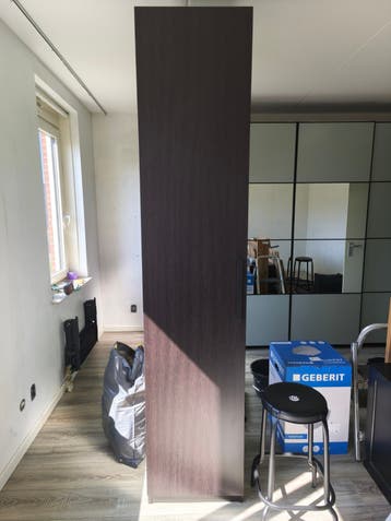 Hoge smalle kast met planken en deur