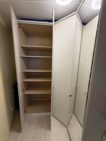Witte hoekkledingkast met planken en hangruimte