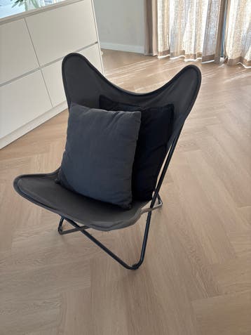 Comfortabele grijze vlinderstoel met kussens