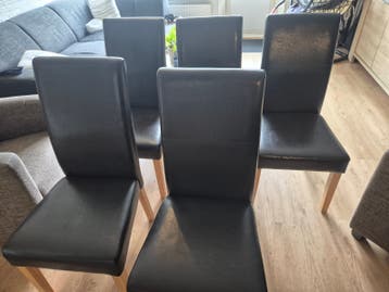 GRATIS Zes bruinzwarte eetkamerstoelen met houten poten.
