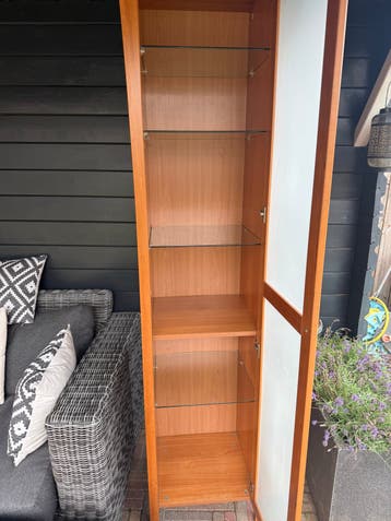 Hoge en smalle kast met glazen planken