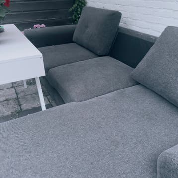 Grijze hoekbank met slaapfunctie en opbergruimte
