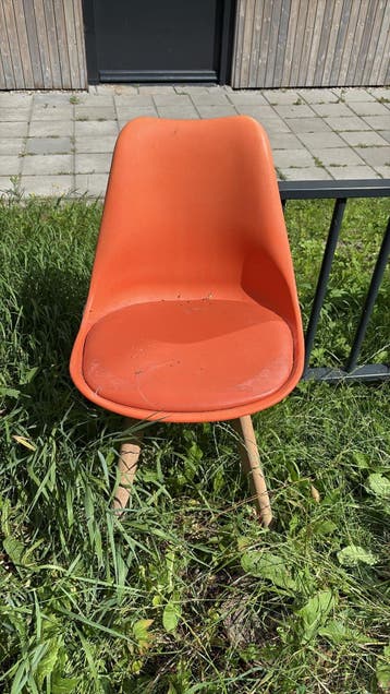 Vier oranje stoelen met houten poten