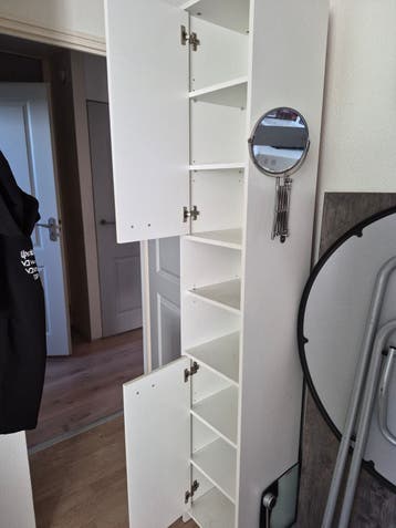 Witte smalle kast met planken en deurtjes