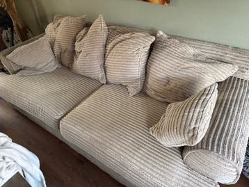 Comfortabele beige ribstof bank met kussens