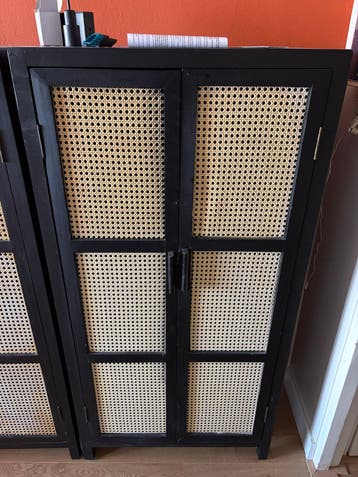 Zwart rotan kastje met gebruikssporen en losse hendel