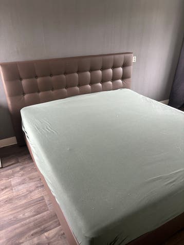 Tweepersoonsbed met gestoffeerd hoofdbord
