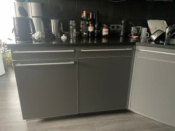 Donkergrijze SieMatic keuken met aluminium en graniet blad.