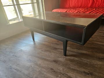 Zwarte salontafel met glazen blad en opbergruimte