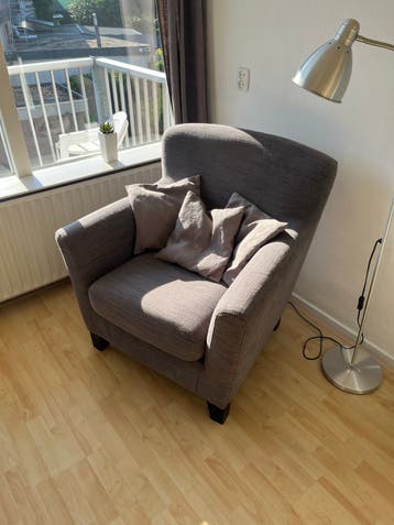 Comfortabele grijze fauteuil met kussens