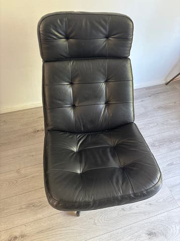 Zwarte leren fauteuil met gebruikssporen