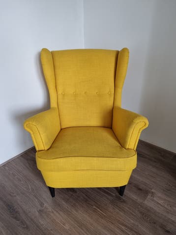 Gele oorfauteuil met gebruikssporen