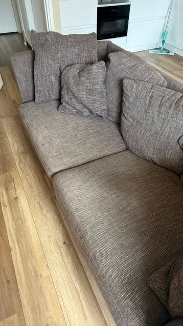 Comfortabele bruine stoffen bank met kussens