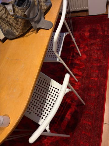 Four witte stoelen met geperforeerde rugleuning