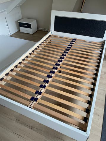 Tweepersoonsbed met lattenbodems en nachtkastje