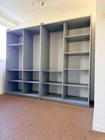 Grote grijze kledingkast met planken en hangruimte