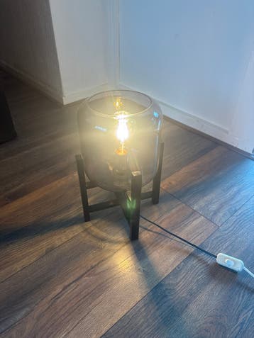Moderne lamp met glazen kap en houten voet