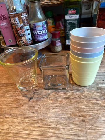 Plastic bekertjes en glazen waxinelichthouders