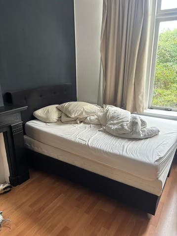 Tweepersoonsbed met gestoffeerd hoofdbord