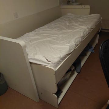 Wit eenpersoonsbed met opbergruimte