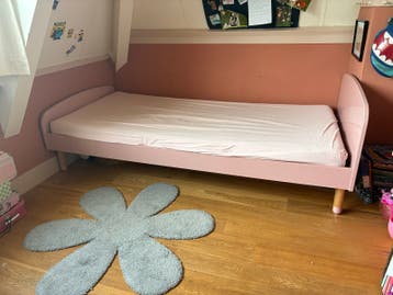 Roze eenpersoonsbed met houten poten