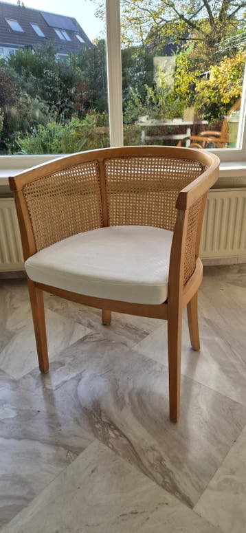 Rotan stoel met houten frame en wit kussen