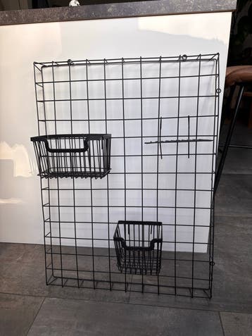Zwart metalen rasterbord met mandjes