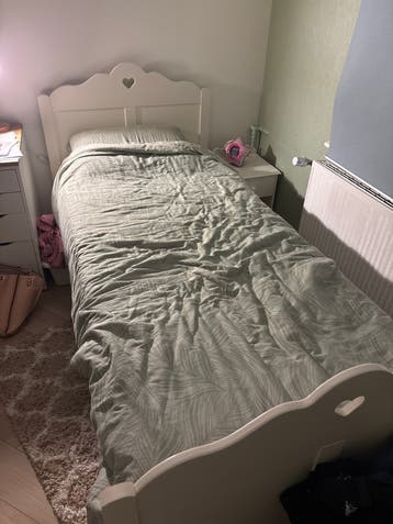 Eenpersoonsbed met hartjes en nachtkastje