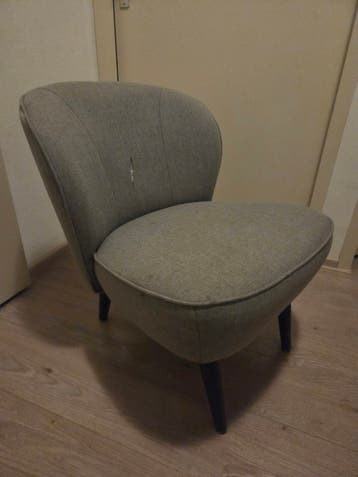 Grijze fauteuil met lichte beschadiging